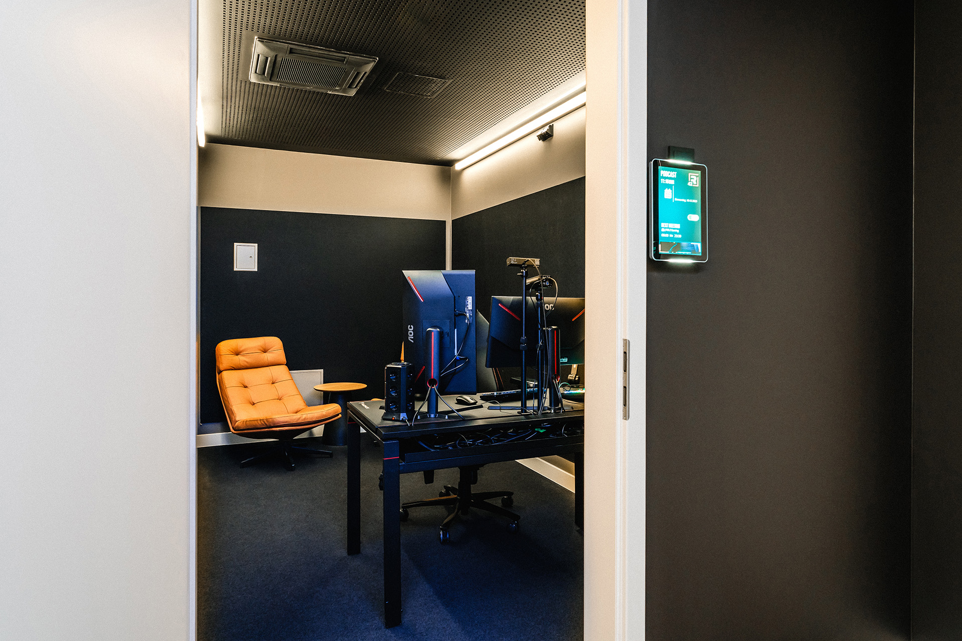 Blick ins das Podcast-Studio im R42 mit zwei Ledersesseln und Gaming Setup für Livestreams.